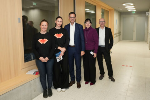 Fünf lächelnde Personen (darunter Landeshauptmann Mag. Markus Wallner, Pflegedirektorin LKH Rankweil Elke Kovatsch, MSc MBA und Chefarzt des LKH Rankweil und Primar Erwachsenenpsychiatrie Prim. Dr. Jan Di Pauli) stehen gemeinsam vor einer Holzverkleidung im Flur.