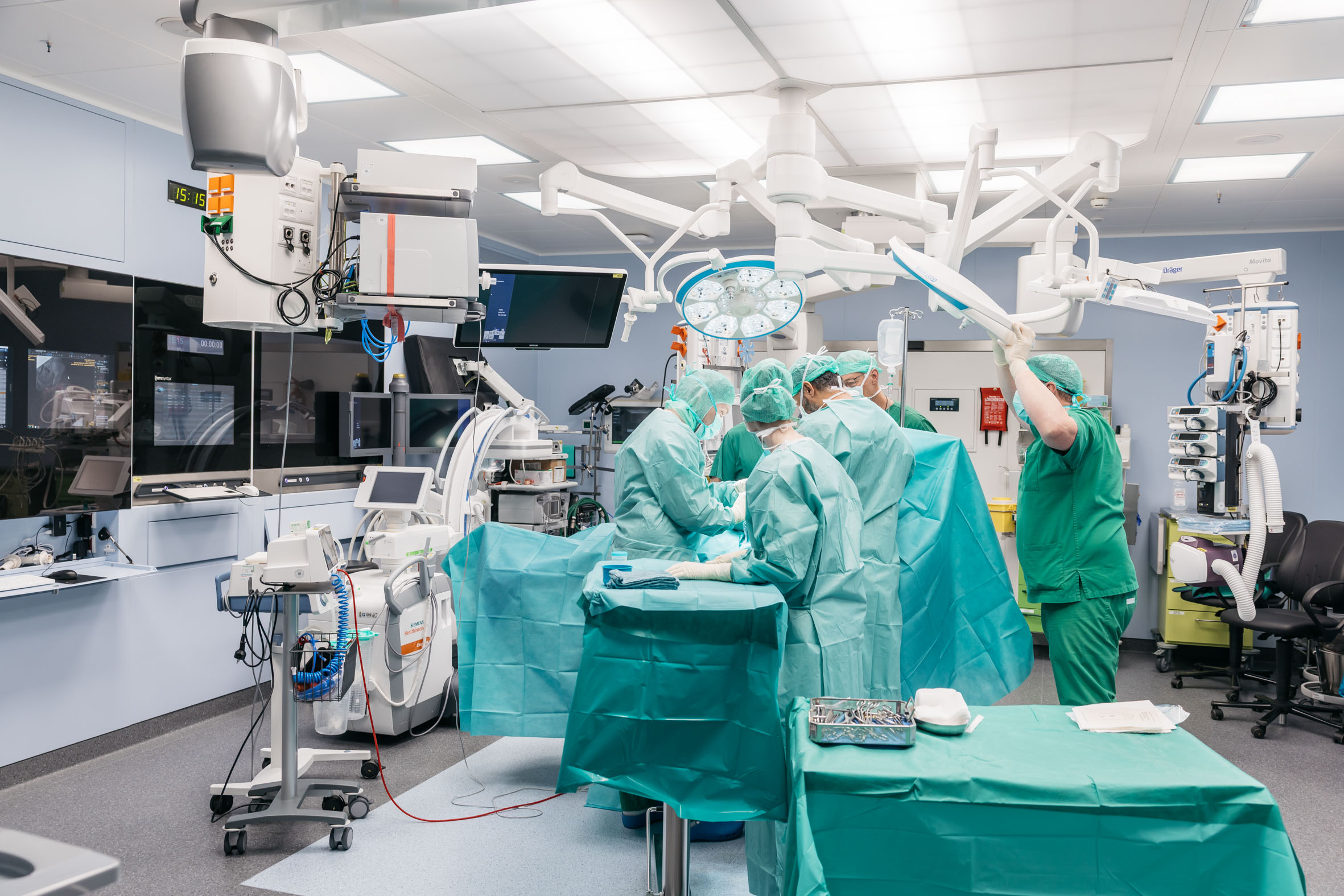Operations-Team in grüner Schutzkleidung bei einem medizinischen Eingriff unter modernen OP-Leuchten in einem neu ausgestatteten OP-Saal des LKH Bludenz.