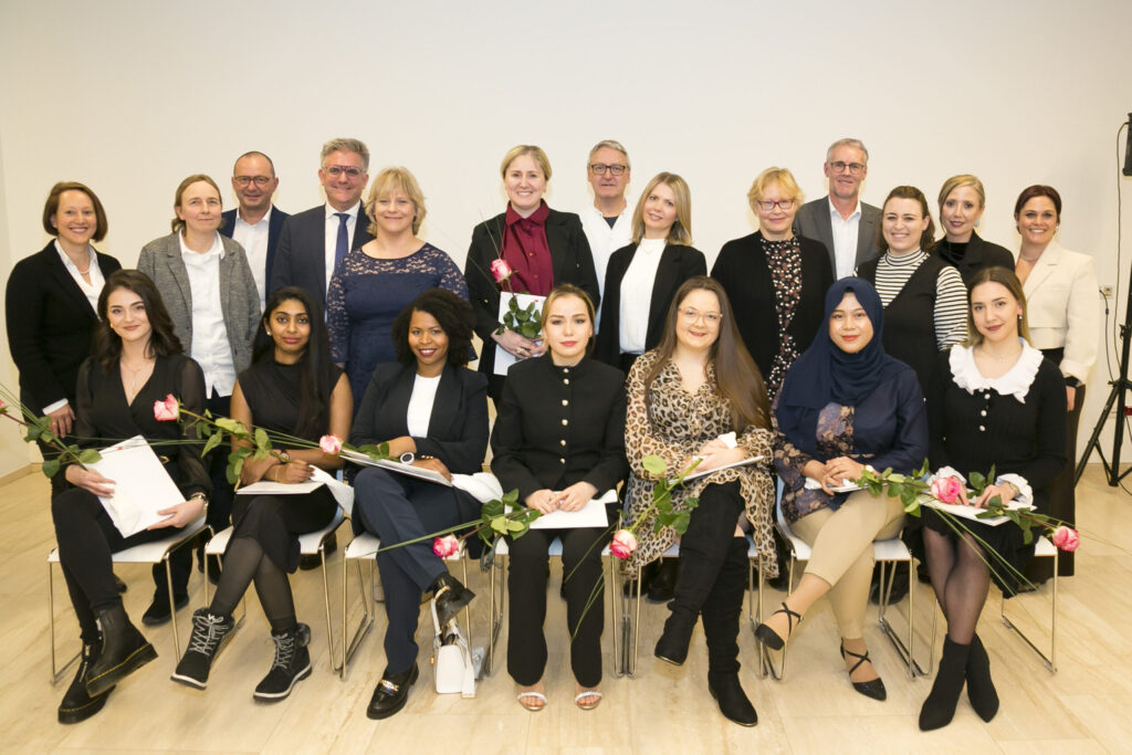 Internationale Pflegekräfte feiern den erfolgreichen Abschluss ihrer Nostrifikation zur Pflege- und Pflegefachassistenz mit Rosen und Zertifikaten am Lernort Bregenz.